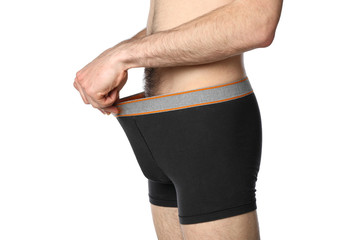 A man looks into his underpants, isolated on white background