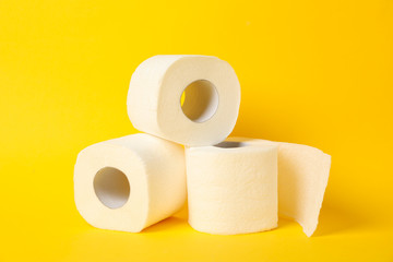 Rolls of toilet paper on yellow background