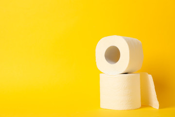 Toilet paper on yellow background, space for text