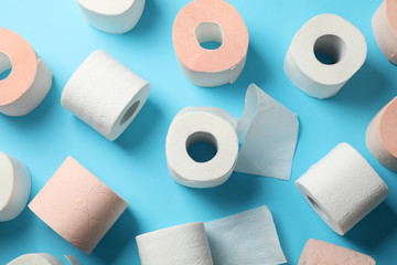 Rolls of toilet paper on blue background, top view