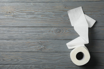 Roll of toilet paper on wooden background, space for text