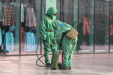 Naklejka na ściany i meble People in bio viral hazard protective suits. Disinfection and decontamination on a public place as a prevention against Coronavirus disease 2019, COVID-19.