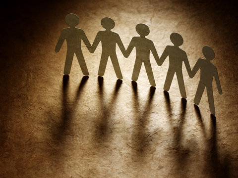 Group of paper people holding hands.