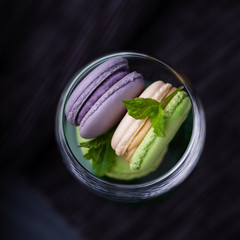 Homemade french violet lavender and mint macaroons or macarons on dark background