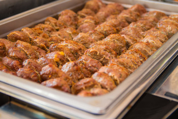 Fried meatballs with herbs in a hot catering baking food tray