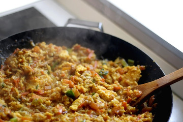 Stir-fry rice with vegetables and eggs in a wok. Selective focus.