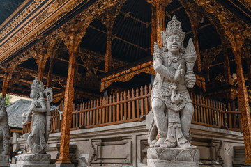Fototapeta premium A close up on a guardian figure next to Pura Tirta Empul temple on Bali. Traditional and historical site. Sculpture of a Balinese temple guardian