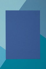 Blue background, colored paper geometrically divides into zones, frame, copy, space.