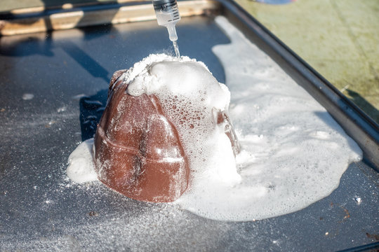 Close up view of a children's volcano experiment using baking powder and vinegar to simulate a volcanic eruption.