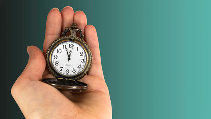 5 minutes to 12 o'clock. Old pocket watch in young woman's hand. Copy space area for text. 