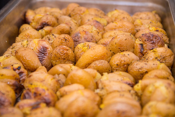 Close up of golden roasted potatoes in skin with oregano 