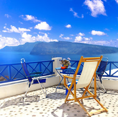 Romantic greek holidays in most beuatiful island Santorini. coffe table with gorgeous caldera and volcano view - obrazy, fototapety, plakaty