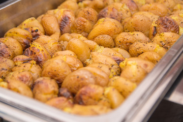 Golden roasted potatos in skin in a hot catering baking food tray