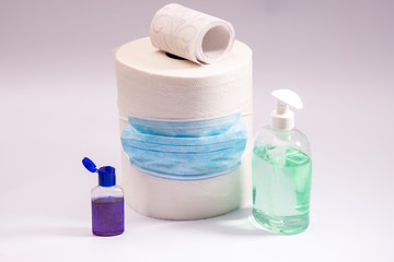A large roll of toilet paper or paper towels antibacterial soap and hand antiseptic with a medical mask