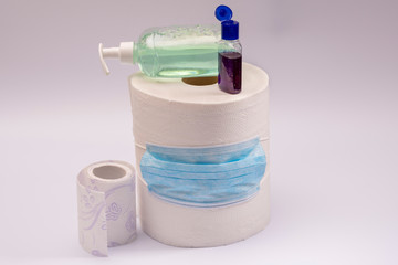 A large roll of toilet paper or paper towels antibacterial soap and hand antiseptic with a medical mask