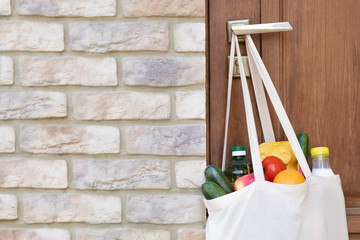 Grocery shopping in a bag hanging on door handle during a quarantine