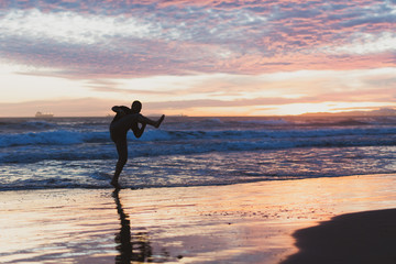 Chico joven haciendo disfrutando de la playa al atardecer