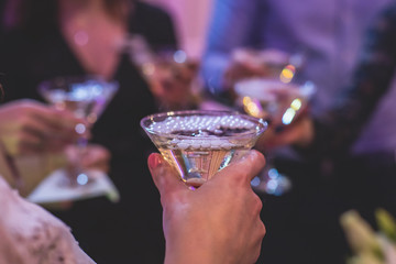 Glasses with alcoholic beverages in the pyramid, beautiful pyramid line of different colored alcohol cocktails with champagne on a wedding party, catering banquet table