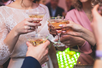 Glasses with alcoholic beverages in the pyramid, beautiful pyramid line of different colored alcohol cocktails with champagne on a wedding party, catering banquet table