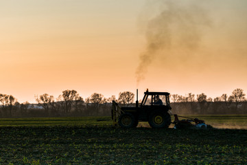 Obraz premium tractor farming sunset