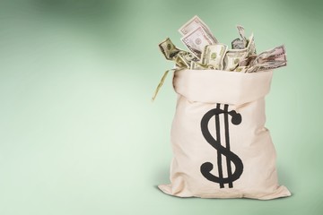 Money bag with dollars money on a desk