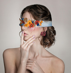 Fashion photo of a girl in a bandage decorated with dry flowers