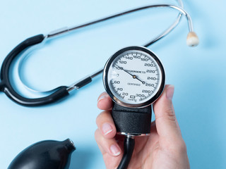 a woman's hand holds a blood pressure monitor that shows blood pressure