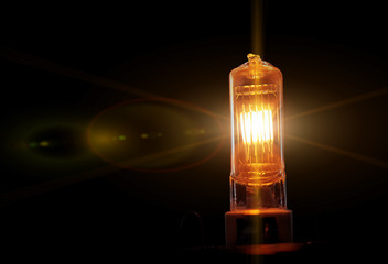 Burning lightbulb filament. Electric tungsten light bulb on a black background