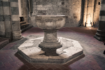 Holy water stoup inside the cathedral of Sovana, Italy. Stoup stone.