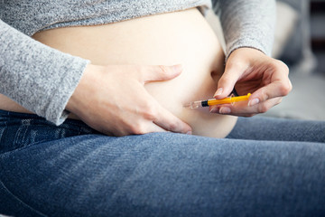 Pregnant woman makes an injection with one-use syringe at home