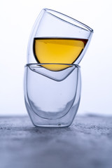 double glass espresso cups on black background with tea