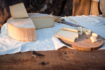 Matured cheese on wooden cutting board.
