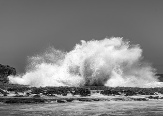 Big Ocean waves crashing into rocks and exploding.