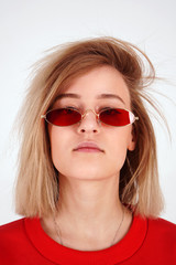 Naklejka premium Vertical portrait - girl in red glasses, woman on a white background