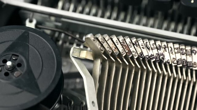 Close-up footage of dirty individual hammers of typewriter. Metal letters and elements of vintage and retro device with copy space.