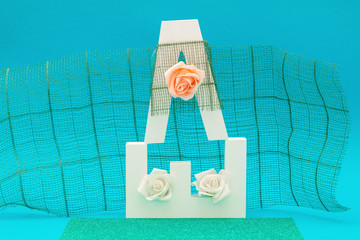 Letter objects with flowers, roses and decorations on a blue background