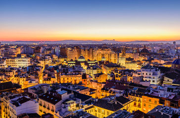 Sightseeing of Spain. Aerial view of Valencia at sunset. Illuminated city, panoramic cityscape of Valencia with beautiful sky.