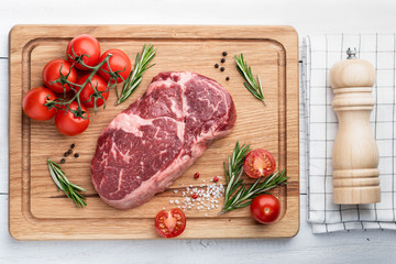 ribeye steak on a wooden board. raw meat, beef. View from above