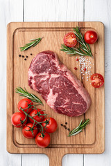ribeye steak on a wooden board. raw meat, beef. View from above