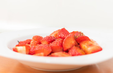 plate of strawberries cut with brown sugar