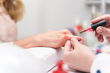 Focused photo on female hand that polishing nail