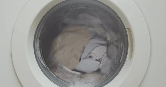 Closeup of a front load washing machine cleaning clothes