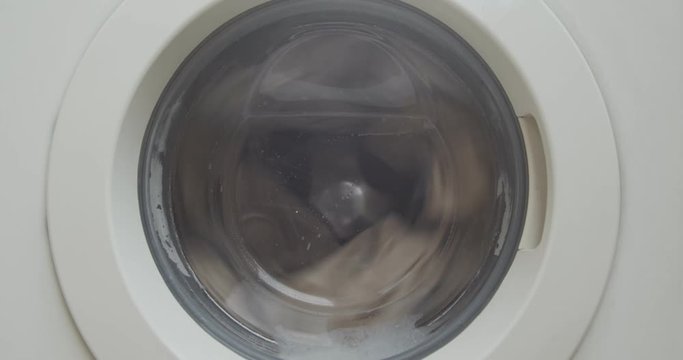 Closeup of a front load washing machine drying clothes