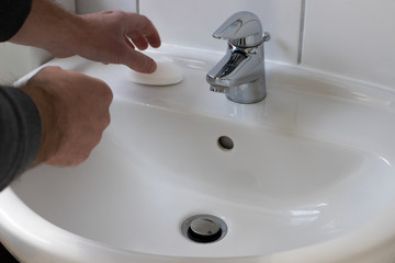 Detail of a Young male washing his Hands with Soap under running water in order to reduce infection Risk during corona Virus pandemic