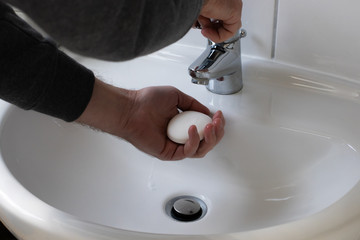 Detail of a Young male washing his Hands with Soap under running water in order to reduce infection Risk during corona Virus pandemic