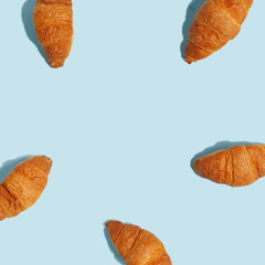 Appetizing crunchy croissants on a blue background. A look from above