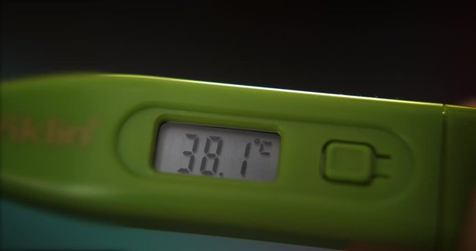 Checking body temperature with thermometer with a fever result