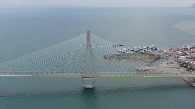 Aerial view of long cable-stayed Rio bridge in Greece at clouds weather, Ferry station