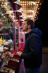 Man trying his luck at the carnivals claw machine