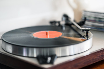 vinyl record turntable on wooden base playing a vinyl record